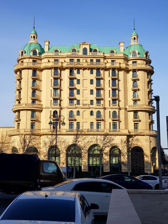 Central Baku Luxury Boulivard Apartment في باكو: مبنى كبير فيه سيارات تقف امامه