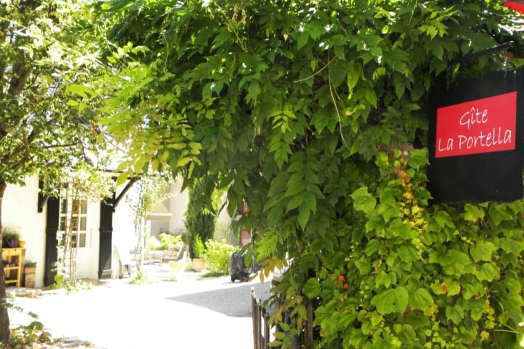 un panneau sur un mur avec des plantes et un bâtiment dans l'établissement Gîte de charme entre campagne et montagne, à Corbelin