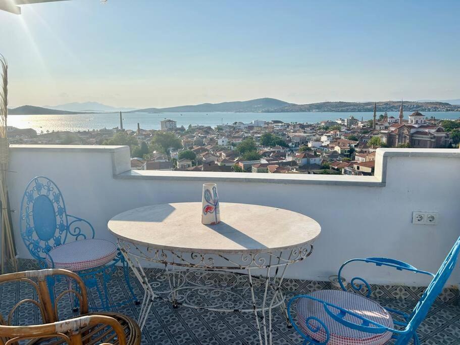 una mesa y sillas en un balcón con vistas en Ayvalık Old Town, Terrace Home with Sea View, en Ayvalık