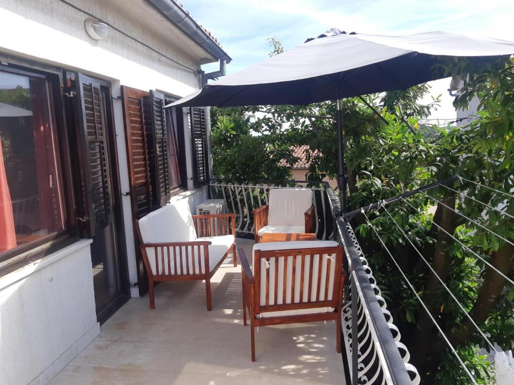 a patio with two chairs and an umbrella at Apartment Marija in Pula