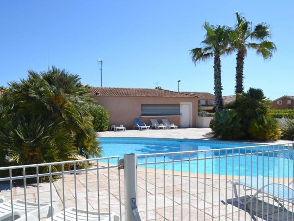 basen z krzesłami i palmami w obiekcie Pavillon 4 pers avec piscine, terrasse, parking, à 700m de la plage et proche commerces - FR-1-701-20 w mieście Vendres