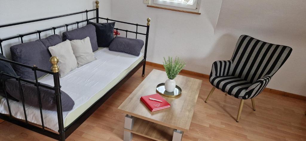 ein Schlafzimmer mit einem Bett, einem Stuhl und einem Tisch in der Unterkunft Ferienwohnung Haus Ella in Neunkirchen