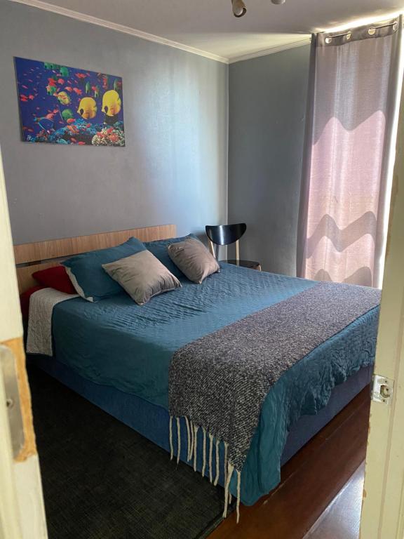 a bedroom with a bed with a blue blanket at Never Give Up Suites in Santiago