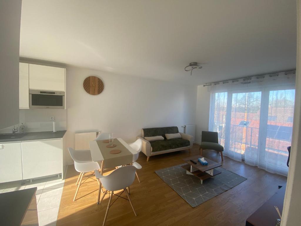 a kitchen and a living room with a table and chairs at Le 147 Parc Entre Paris et Disney in Champigny-sur-Marne