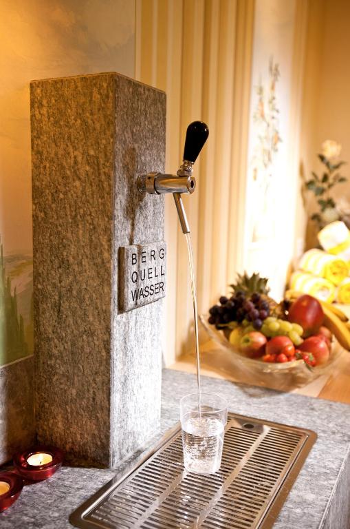 a water fountain on a counter with a bowl of fruit at Chasa Castello relax & spa in Samnaun