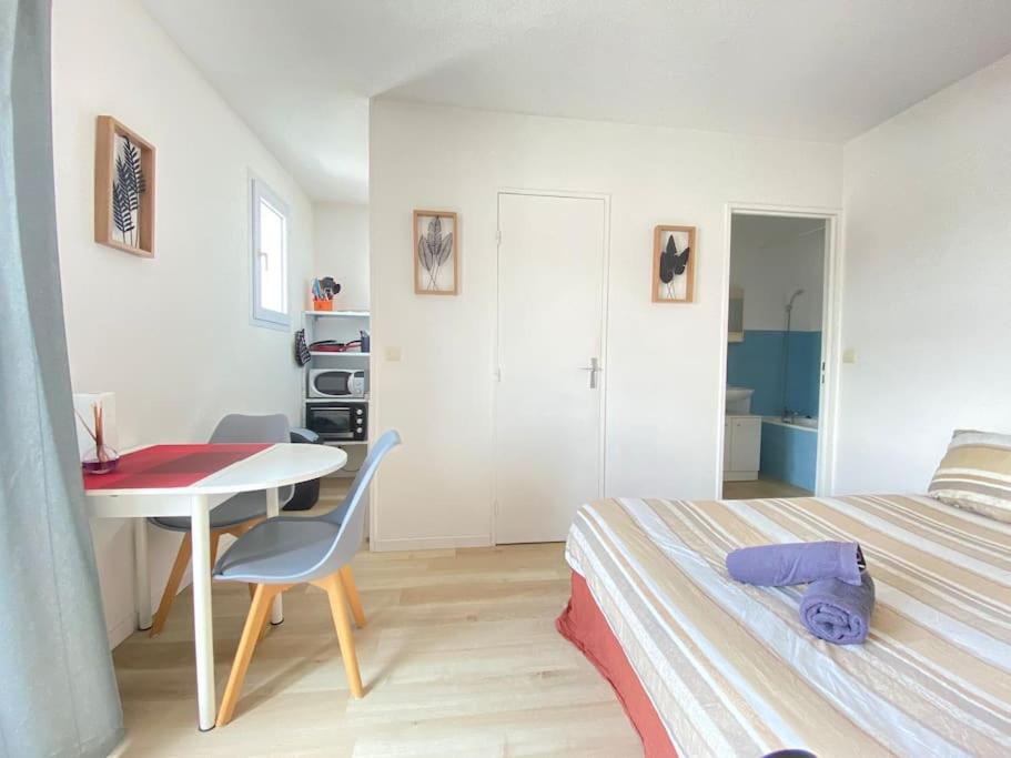 - une chambre avec un lit, un bureau et une table dans l'établissement Petit Studio Corot St jacques, à Clermont-Ferrand