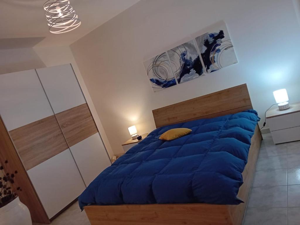 een slaapkamer met een blauw dekbed op een bed bij Pamir Casa Vacanze Appartamento in Trapani