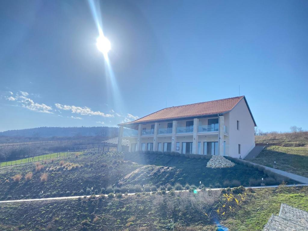 Una casa en una colina con el sol detrás. en Angyal Villa, en Rátka