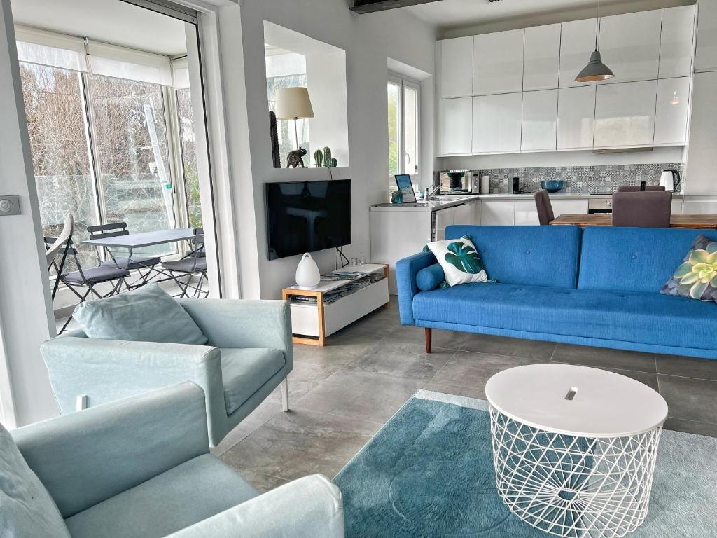 un salon avec un canapé bleu et une cuisine dans l'établissement Villa avec piscine, Baie de Bandol, Accès plage, à Sanary-sur-Mer