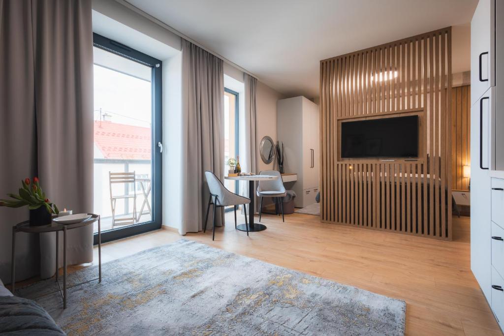 a living room with a television and a table with chairs at GRAY APARTMENT in Banská Bystrica