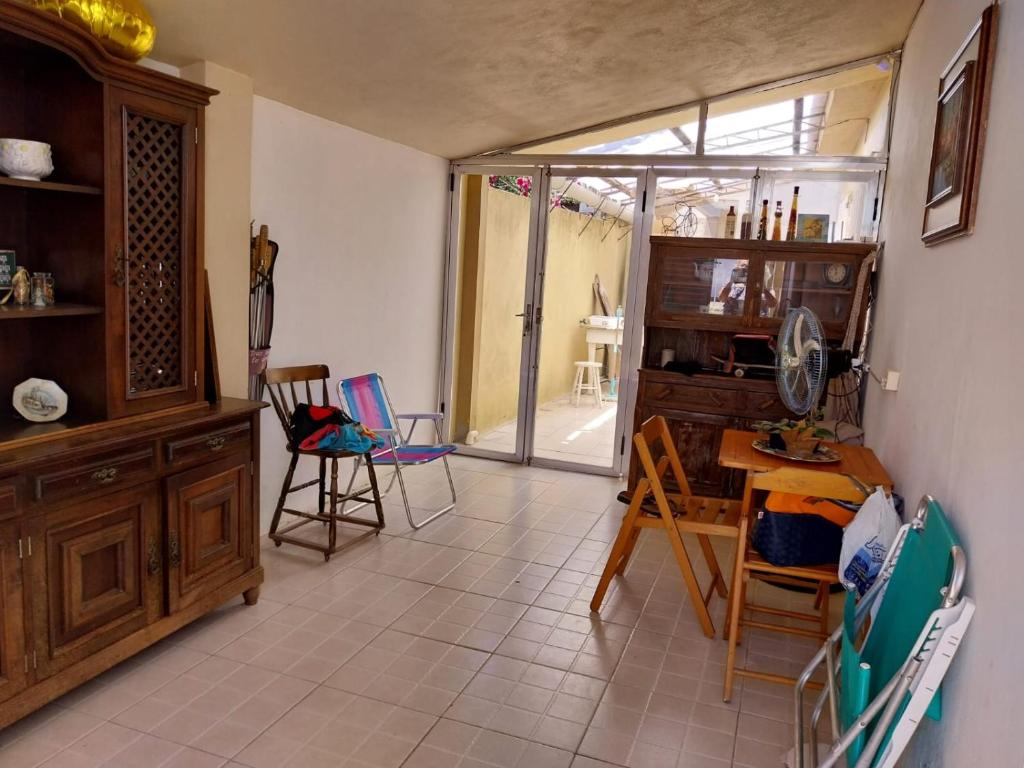 sala de estar con sillas, mesa y puerta de cristal en Casa da Totonha en São Lourenço do Sul