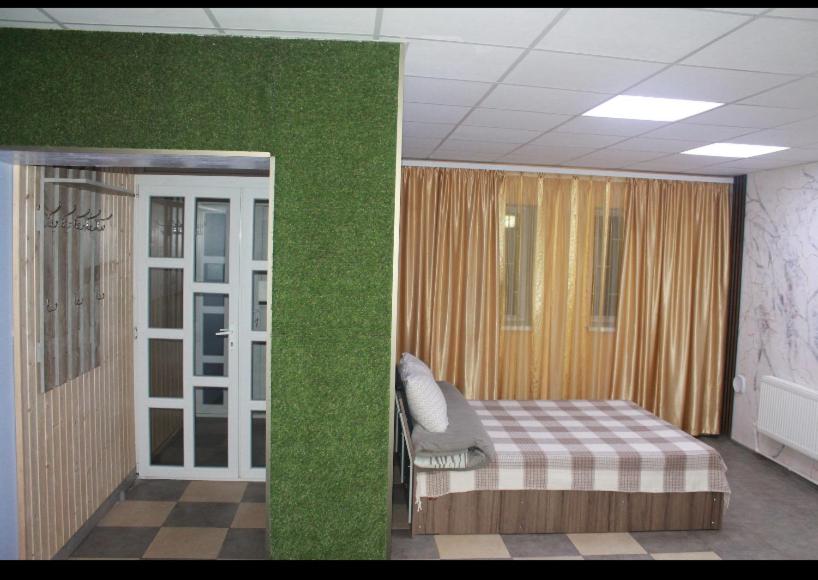 a room with a bed and a green wall at House in downtown in Bălţi