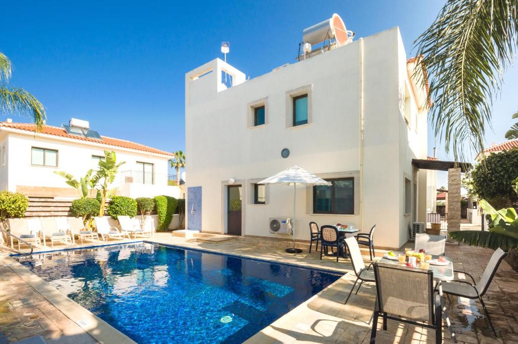 a villa with a swimming pool in front of a house at Villa Maya - 4bed with Private Heated Pool in Paralimni