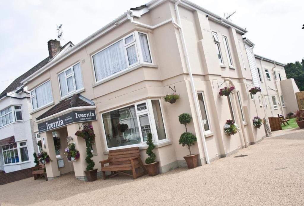 un grand bâtiment blanc avec un banc devant lui dans l'établissement The Ivernia hotel, à Skegness