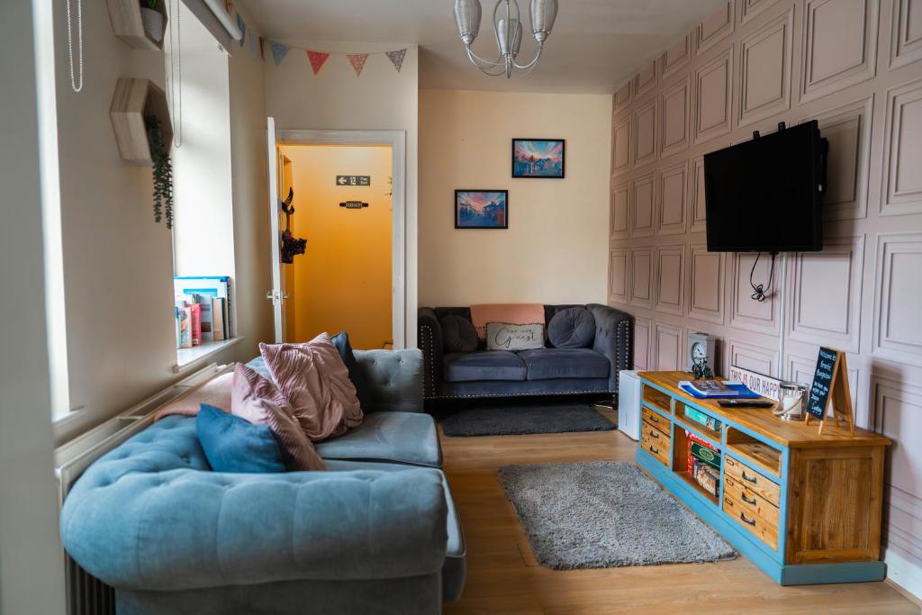 ein Wohnzimmer mit einem Sofa und einem TV in der Unterkunft Bronte Bungalow - In Beautiful Bronte Country! in Oxenhope