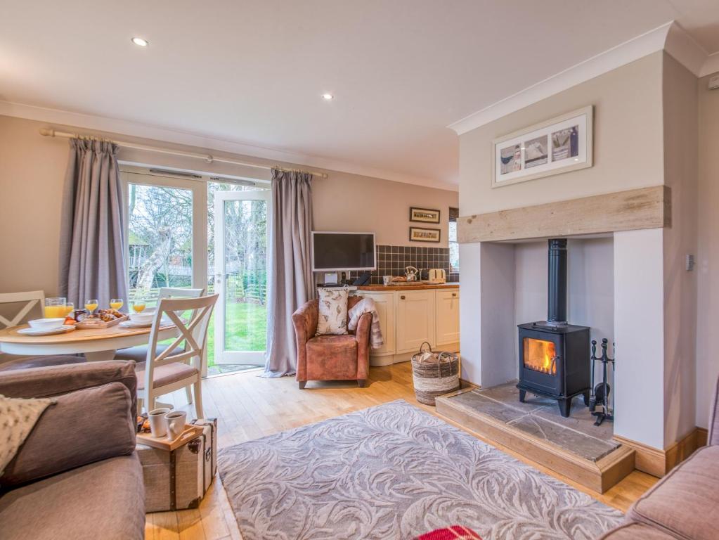 a living room with a fireplace and a table at 2 Bed in Nr Beadnell 77990 in Ellingham
