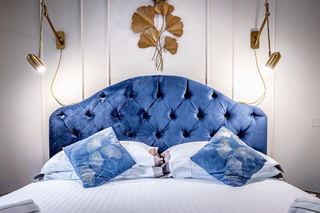 a bed with a blue headboard and pillows at THREE APARTMENTS Via Roma in Florence