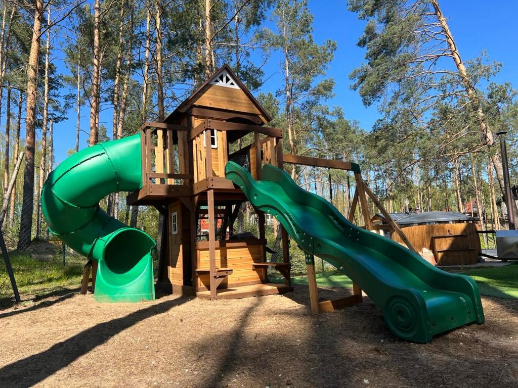 a playground with a slide and a play structure at REST HOUSE WDZYDZE DOMKI NAD JEZIOREM in Wdzydze Kiszewskie
