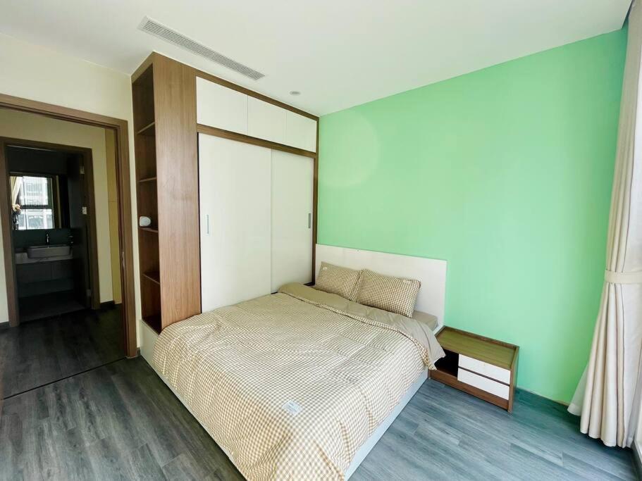 - une chambre avec un lit dans une pièce aux murs verts dans l'établissement Kim's homestay - Vinhomes OCean Park, à Gia Lâm Pho