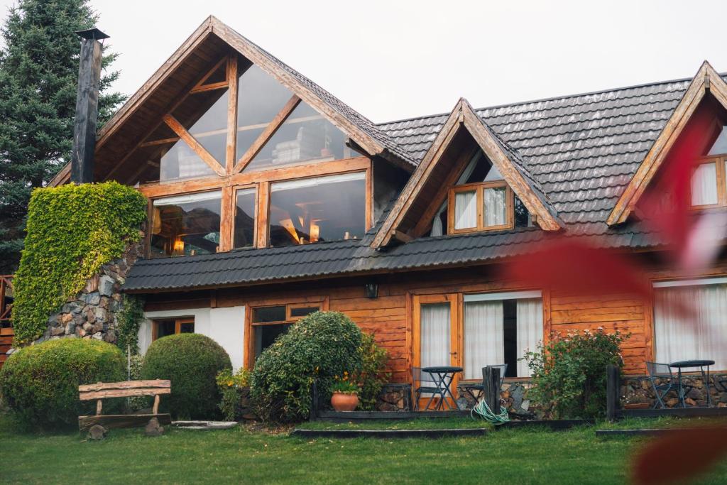 a house with a large window on the front of it at Casa del Lago Villa La Angostura in Villa La Angostura