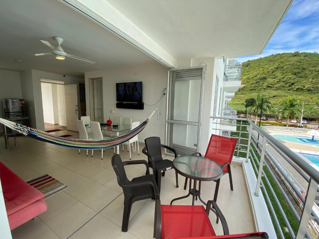 balcón con hamaca, mesa y sillas en Aqualina Orange Apartamento Piso 3 Vista a Piscina 3 Habitaciones, en Girardot
