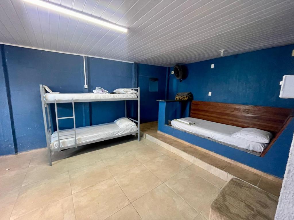 a room with two bunk beds and a blue wall at Pousada Alojamento AS in Viracopos