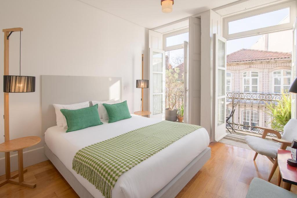 a white bedroom with a large bed and a window at Fil's Place in Porto