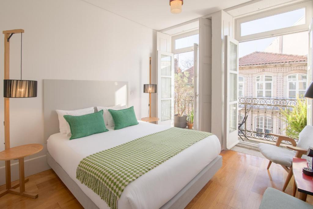 een witte slaapkamer met een groot bed en een raam bij Fil's Place in Porto