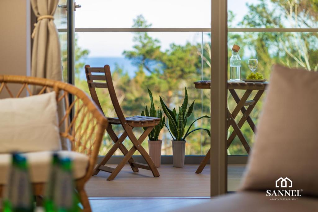 un balcone con tavolo, sedia e finestra di Apartament Lux Sea z dostępem do basenu,saun-Pinea Apartments Pobierowo-SANNEL Apartments for rent a Pobierowo