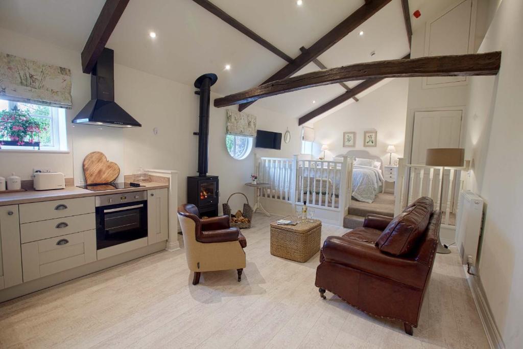 a kitchen and living room with a couch and chairs at Linton Court Coach House in Settle