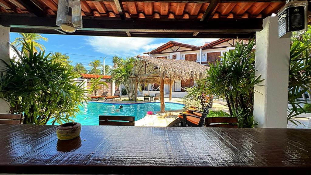 a table with a view of a swimming pool at Hotel Pousada 360 in Paracuru