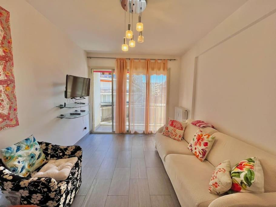 un salon avec un canapé et une télévision dans l'établissement Le Colony, à Cannes