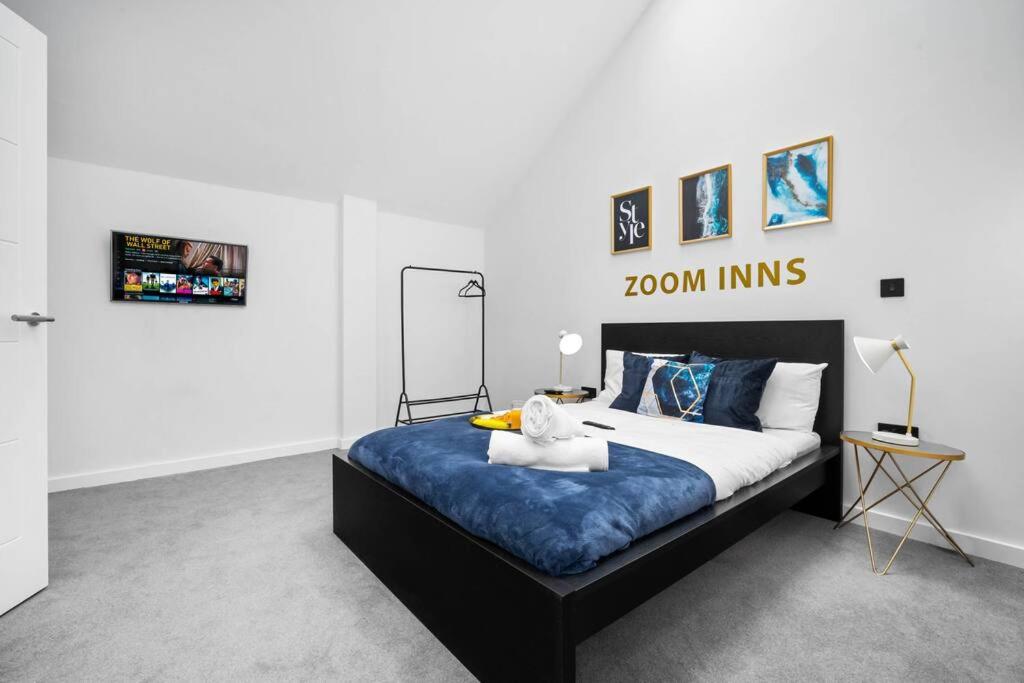 um quarto com uma cama grande com lençóis azuis e brancos em Urban Retreat in Vibrant Deritend! em Birmingham