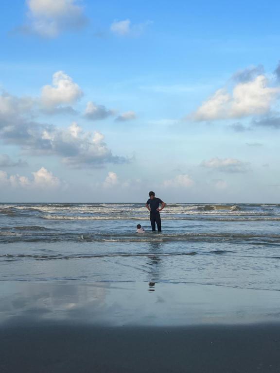 Ein Mann steht im Meer am Strand in der Unterkunft Hakan Beach Villa in Bachok