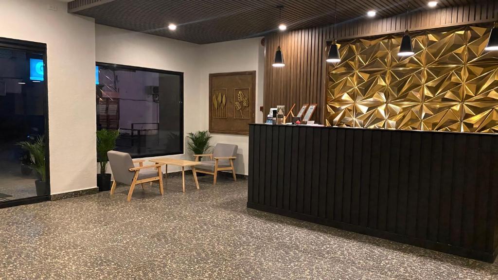 a lobby with a table and chairs in a building at Rudolfo Suites in Roxas City