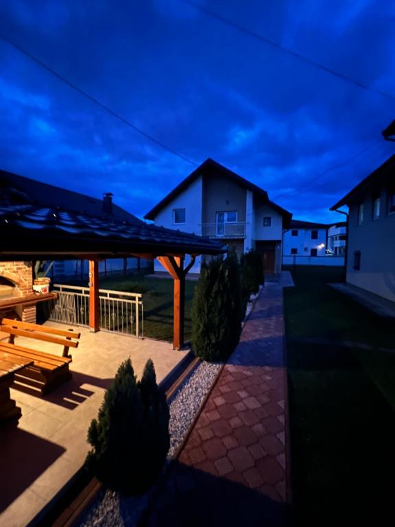 - une terrasse avec une table de pique-nique et des bancs la nuit dans l'établissement Vacation Home MEŠIĆ, à Sarajevo