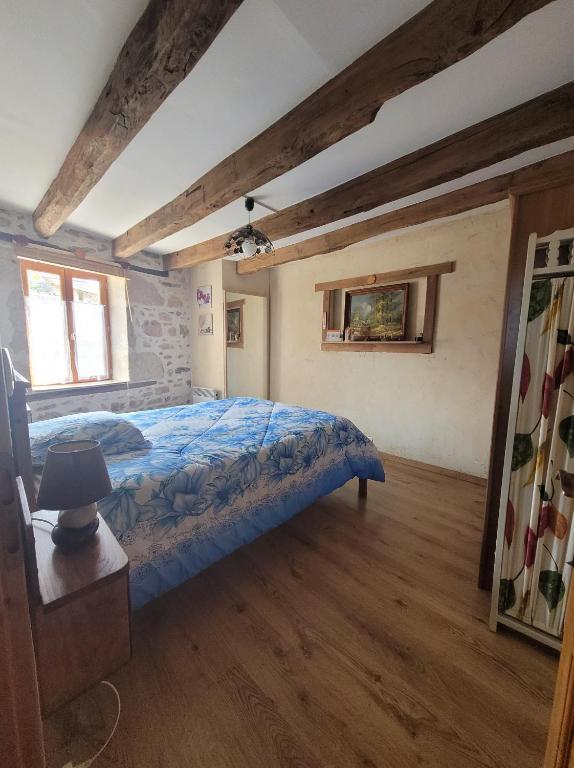 a bedroom with a bed with a blue comforter at Maison dans un havre de paix in Saint-Julien-le-Petit