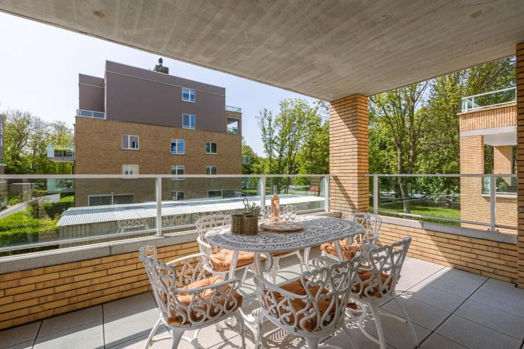 d'une terrasse avec une table et des chaises sur un balcon. dans l'établissement A luminous apartment near the marina, à Ostende