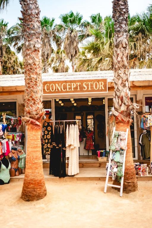a store with two palm trees in front of it at Toison D'or in Saint-Tropez