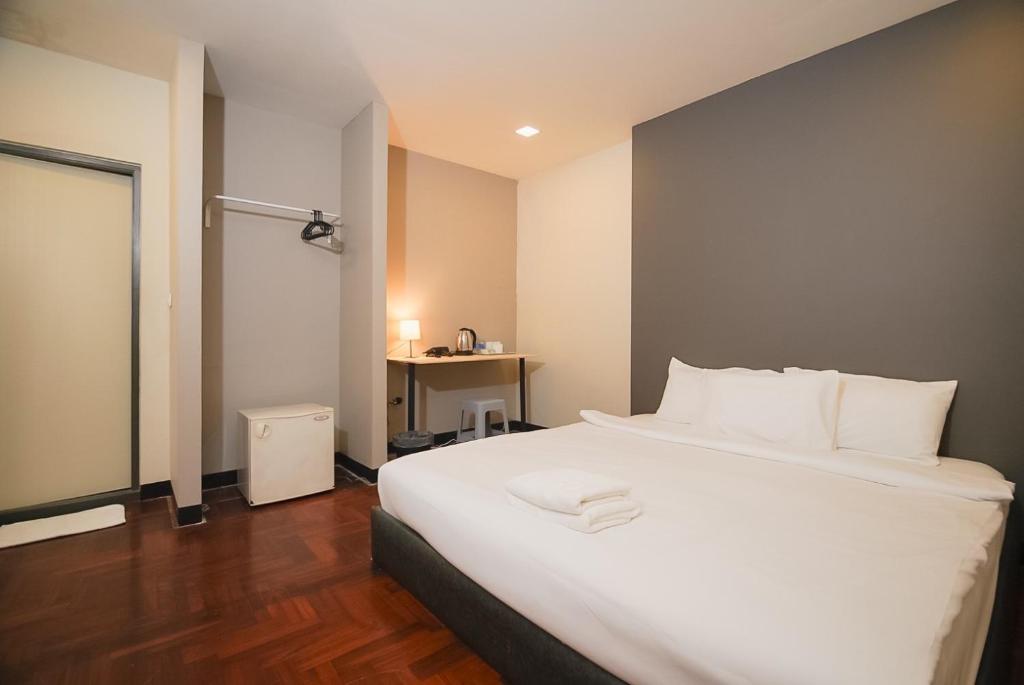 Yan Nawa的住宿－GO INN Silom - BTS Saint Louis โกอินน์ สีลม - สถานีรถไฟฟ้าเซนต์หลุยส์，卧室配有一张白色大床和一张书桌