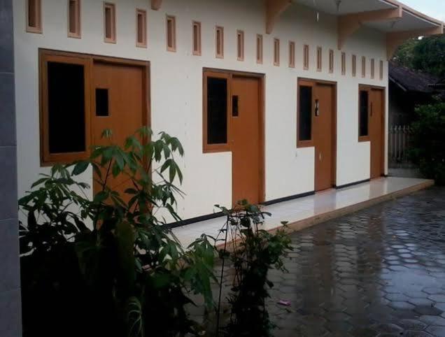 Un bâtiment avec beaucoup de portes sous la pluie dans l'établissement Griya harapan indah, à Kudus