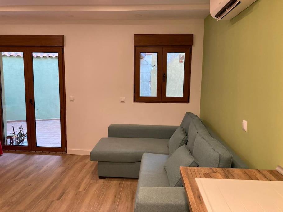 ein Wohnzimmer mit einem Sofa und einem Tisch in der Unterkunft Apartamento Robledo de Chavela Plaza 1A in Robledo de Chavela