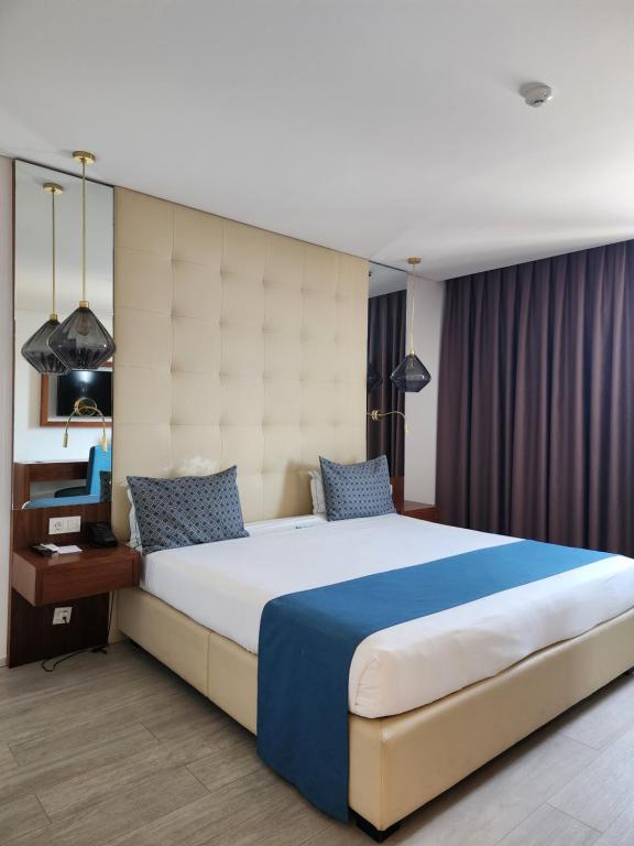 a bedroom with a large bed with a large headboard at Afrin Prestige Hotel in Maputo