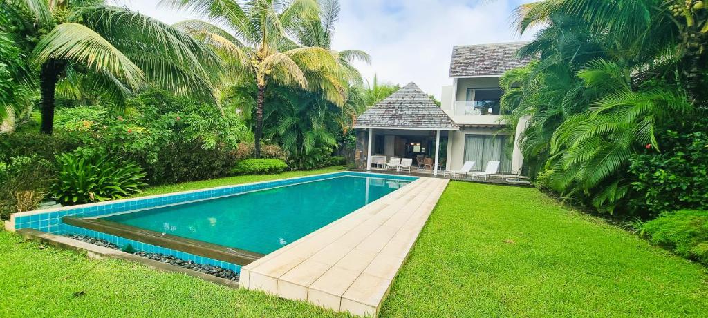 a swimming pool in the yard of a house at Modern Villa with Private Pool at Anahita Golf Resort in Beau Champ