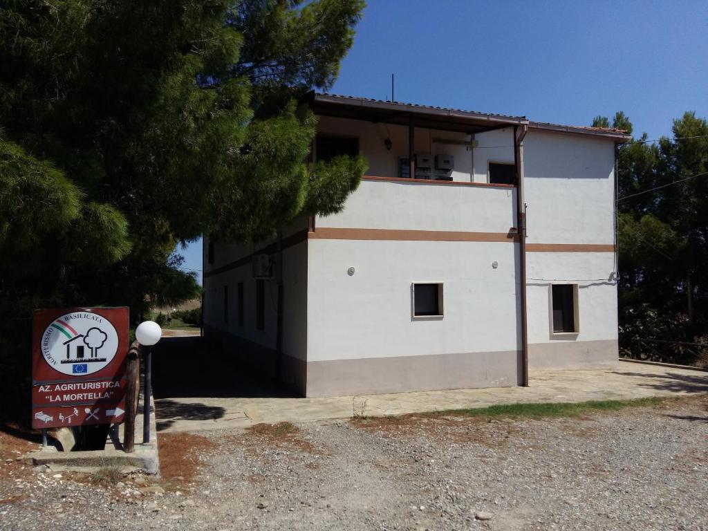 a white building with a sign in front of it at La Mortella Agriturismo in Rotondella