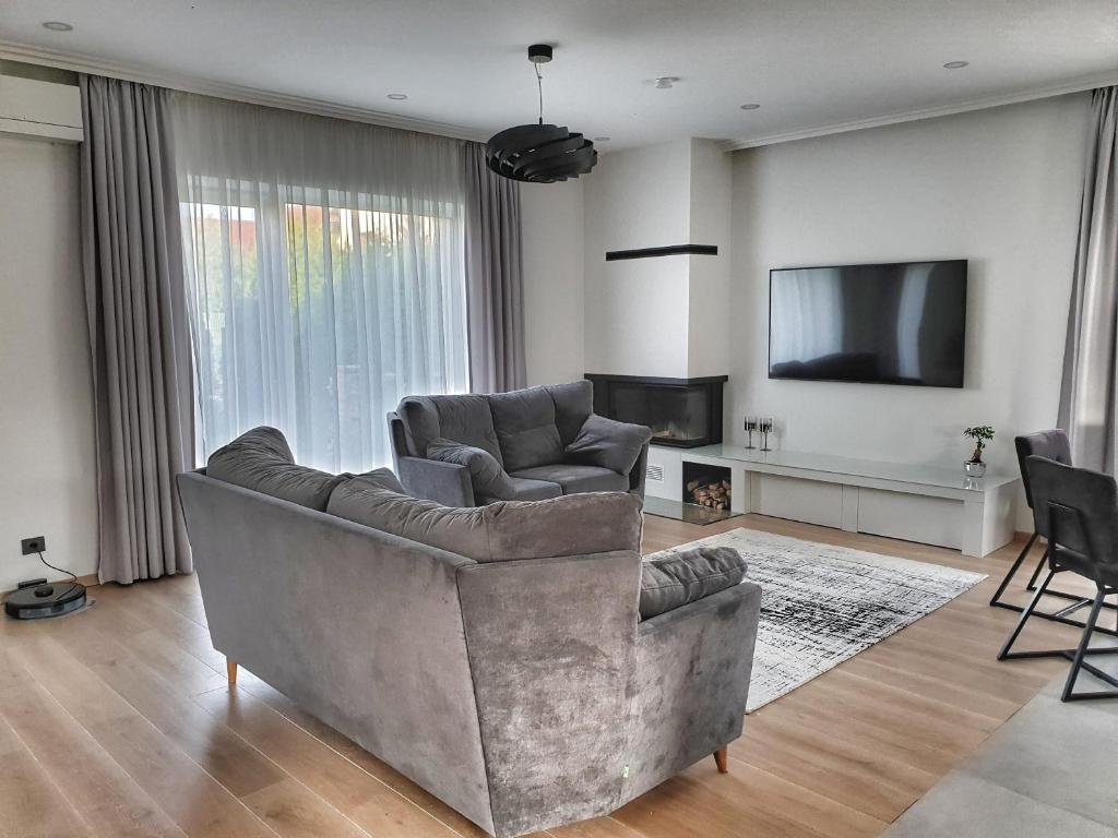 salon z kanapą i telewizorem w obiekcie Luxury Home in Vilnius w Wilnie
