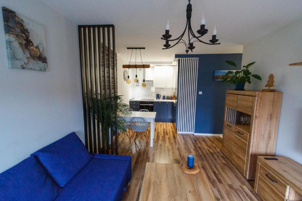 een woonkamer met een blauwe bank en een keuken bij South House in Włocławek