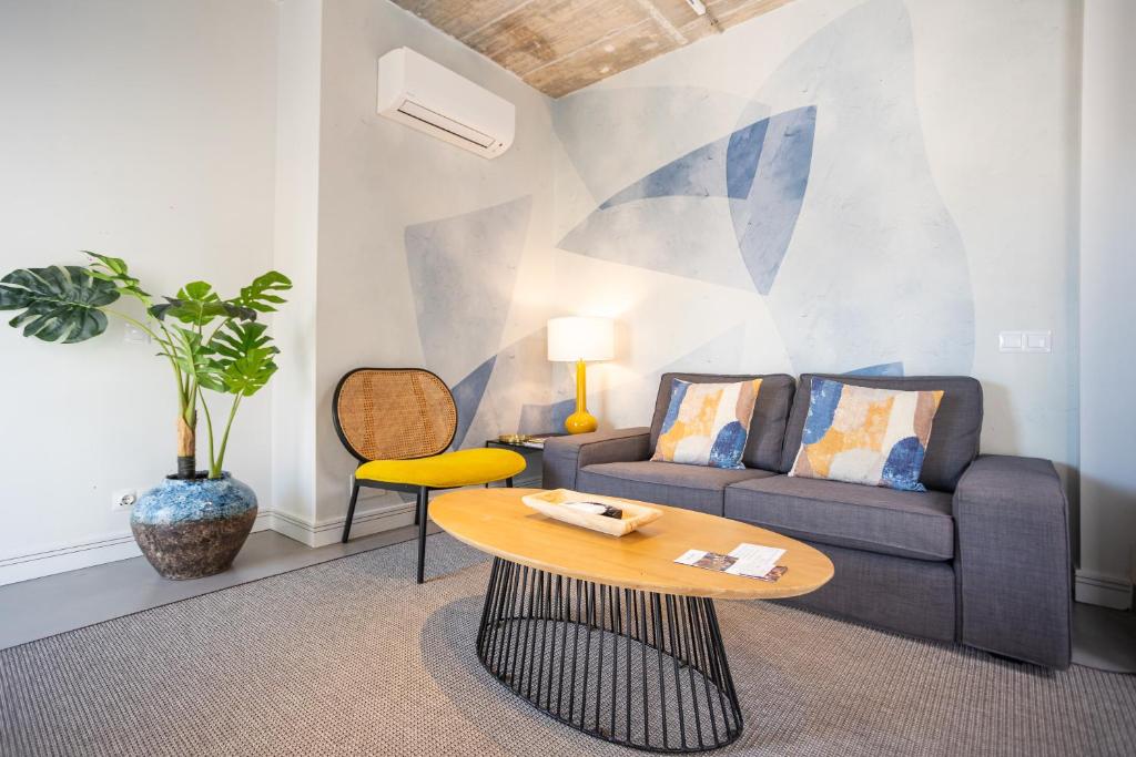 - un salon avec un canapé et une table dans l'établissement Apartamentos 7 dreams, à Malaga
