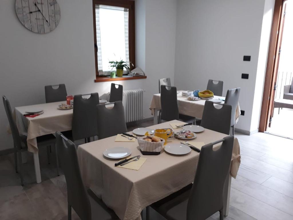 een eetkamer met tafels en stoelen met eten erop bij B&B Vivi l'Attimo in Campodenno
