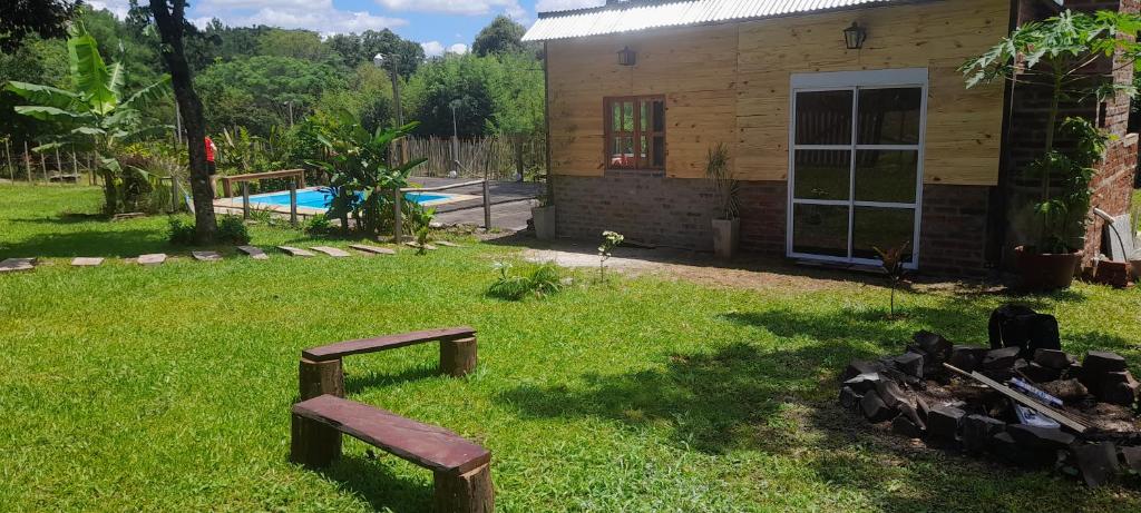 einen Hof mit zwei Bänken vor einem Haus in der Unterkunft Cabaña Don floricel in Santa Ana